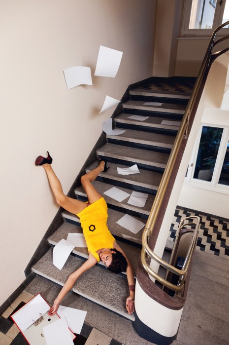 Woman with documents falls down the stairs because of the rush