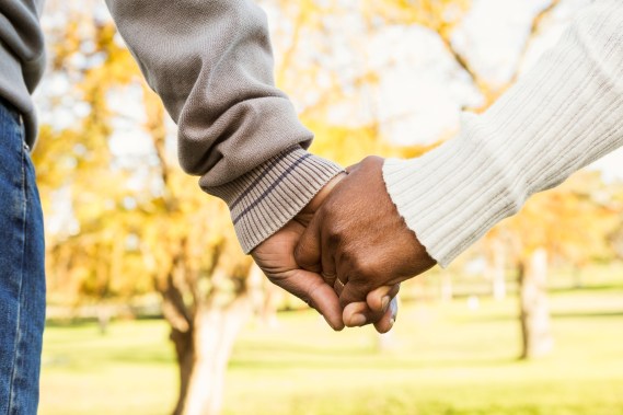 Close up view of senior couple holding hands in parkland